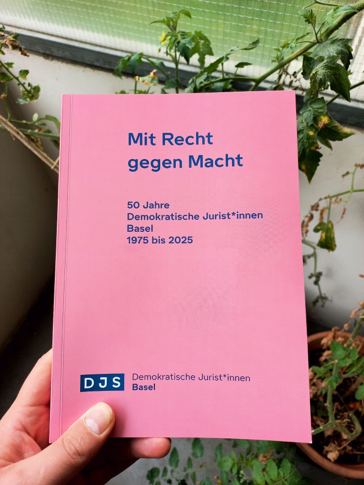 Bild eines Buchs mit dem Titel "Mit Recht gegen Macht - 50 Jahre Demokratische Jurist*innen Basel 1975-2025". Unten auf dem Buch prangt das Logo der DJS Basel, eine Hand hät das Buch.