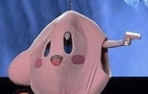 Person in a kirby costume, the left arm is cut out, they are holding a gun