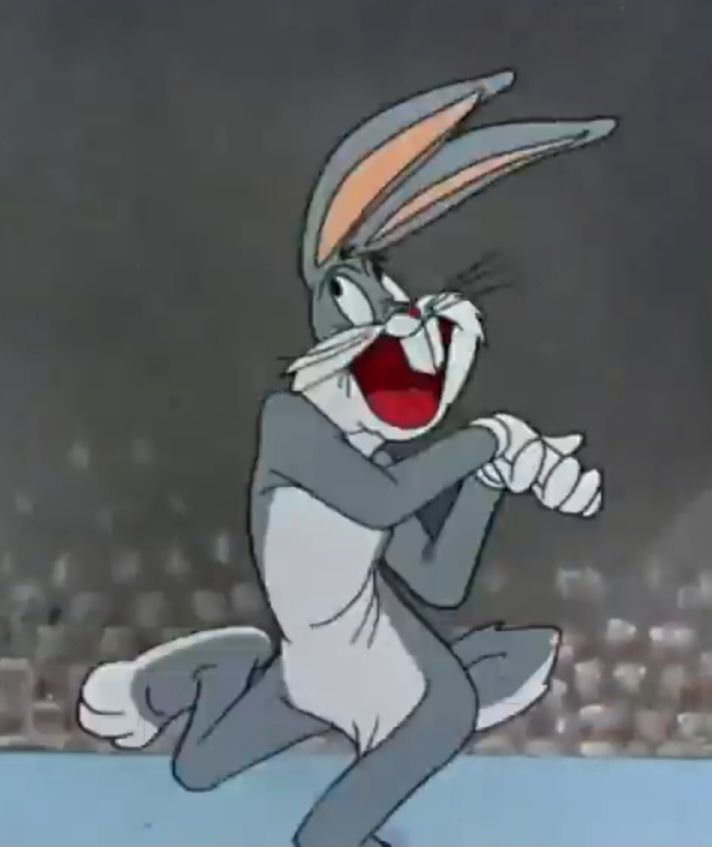 Bugs Bunny clasping his hands together, sticking his right foot partially up in the air away from the viewer, and opening his mouth very wide in a manner the expresses happiness.