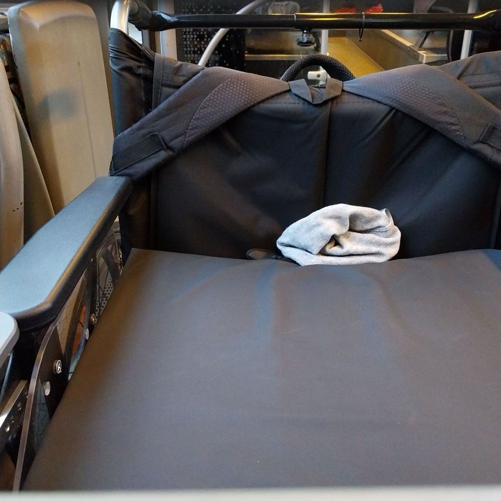 In einen Ausschnitt des Bildes sieht man einen leeren Rollstuhl in einem Bus der Märkischen Verkehrsgesellschaft.