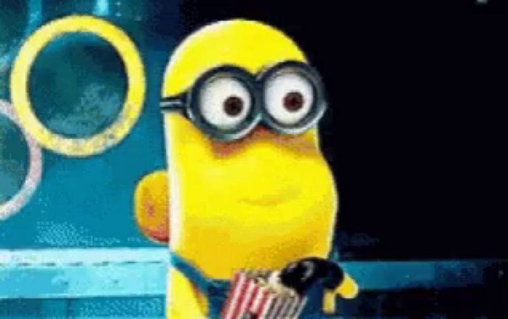 a minion wearing glasses and holding a bag of popcorn