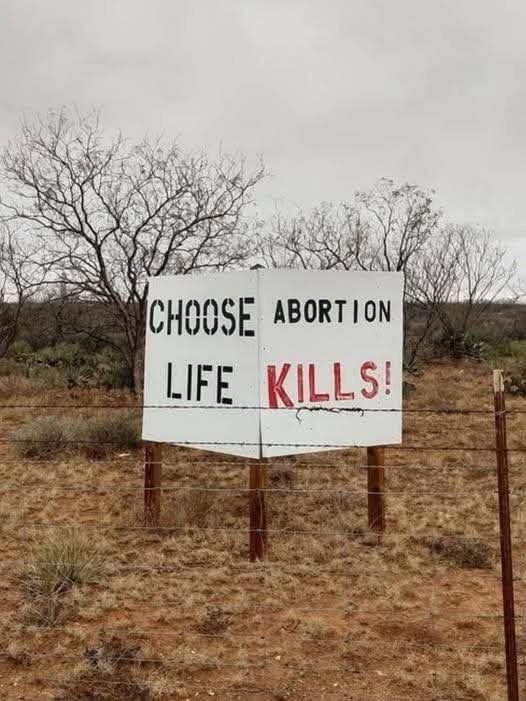 sign that says “CHOOSE LIFE ABORTION KILLS” but due to the poor layout reads as”CHOOSE ABORTION LIFE KILLS”