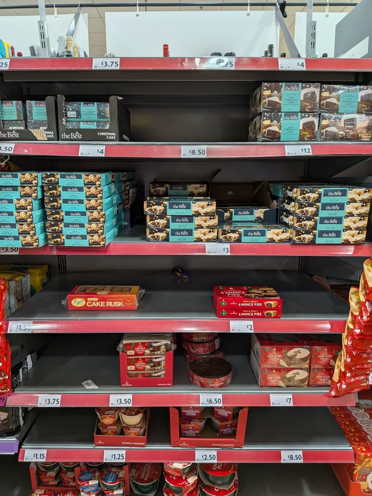 Supermarket shelves stocked with Christmas food, some of which is already gone