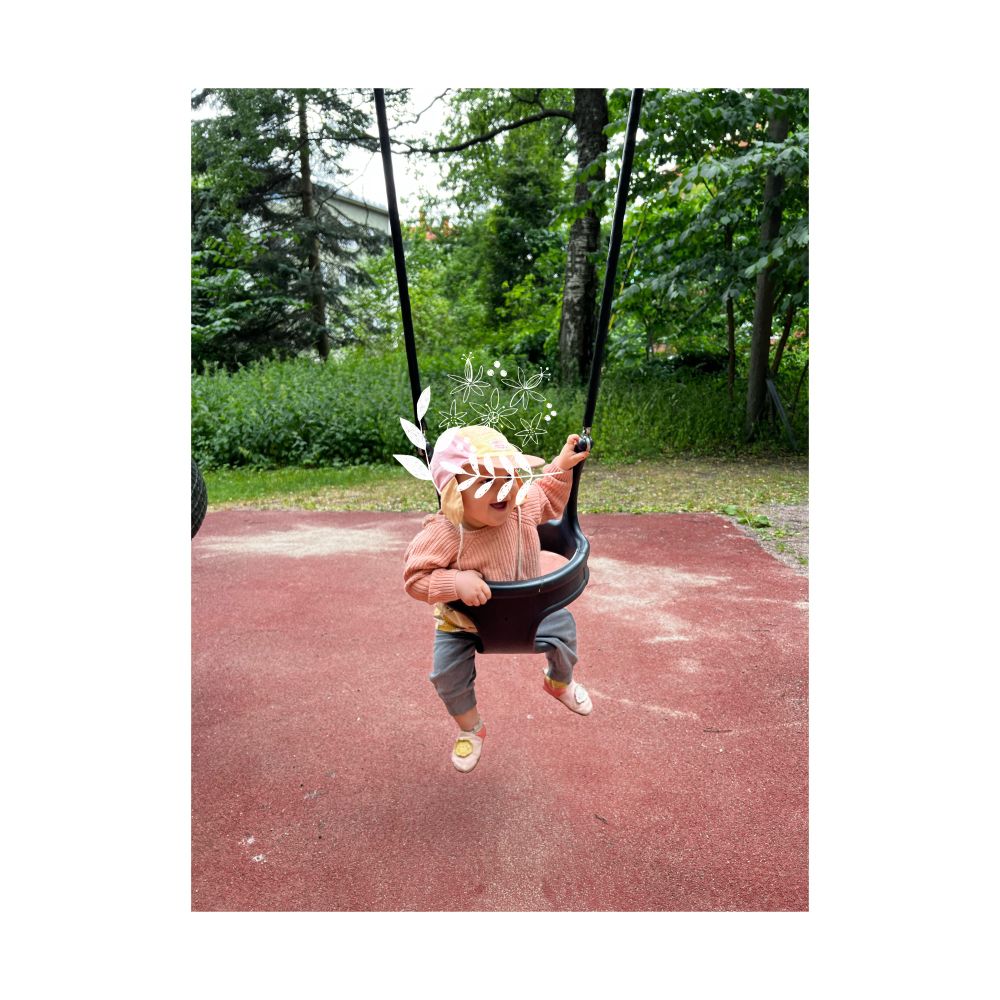 Toddler having fun in a swing.