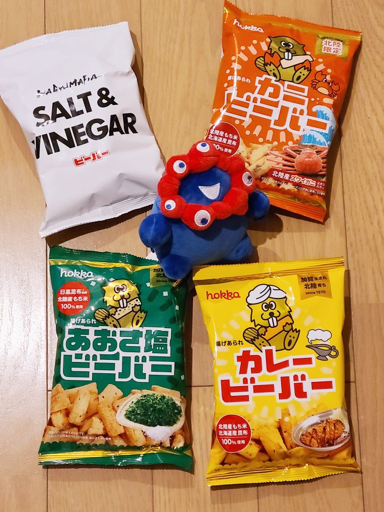 左上からソルト&ビネガーのビーバー、カニビーバー、あおさ塩ビーバー、カレービーバーと中央に丸々としたミャクミャクのぬいぐるみの写真