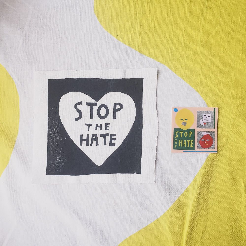 左側にパッチ
(白地の正方形の布に、黒地に白抜きでハート。ハートのなかにSTOP THE HATEと書いてある)
右側にステッカー