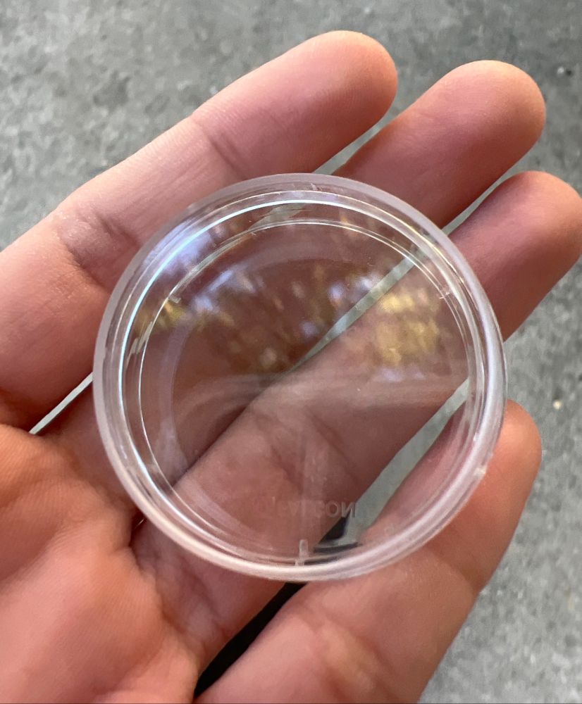 my hand holding a small plastic dish 