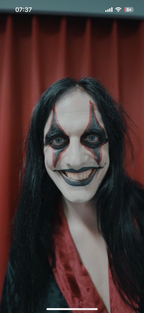 johannes from the band avatar wearing black and red clown face paint. He's wearing a black and red robes