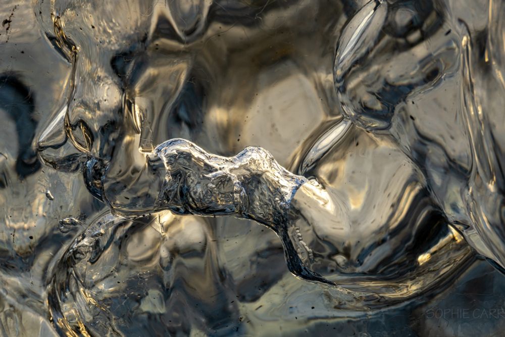 Ice formations inside an iceberg, taken close up. The ice looks like a winding tube made of a gold/silver metal - does not look like ice at all!