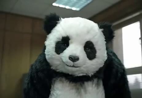 a stuffed panda bear wearing a fur coat