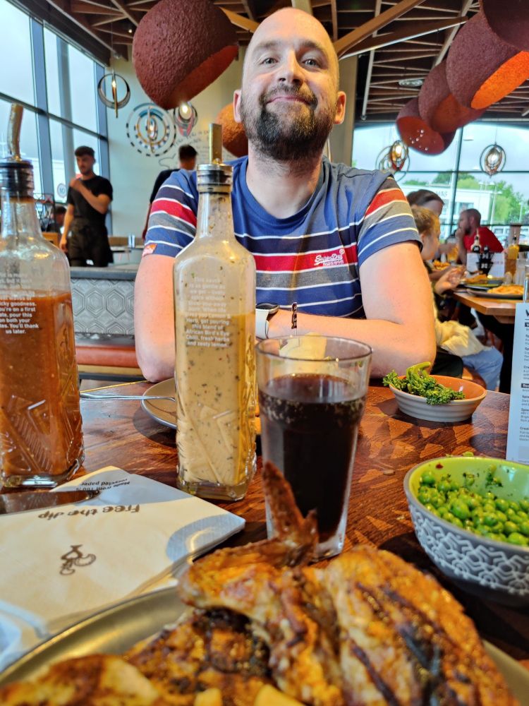 Photo of male partner smiling, with food on table
