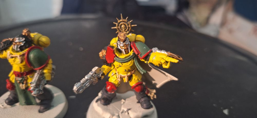 Close up of a space marine figure, yellow body, green shoulders, red trim & knees, and black boots.