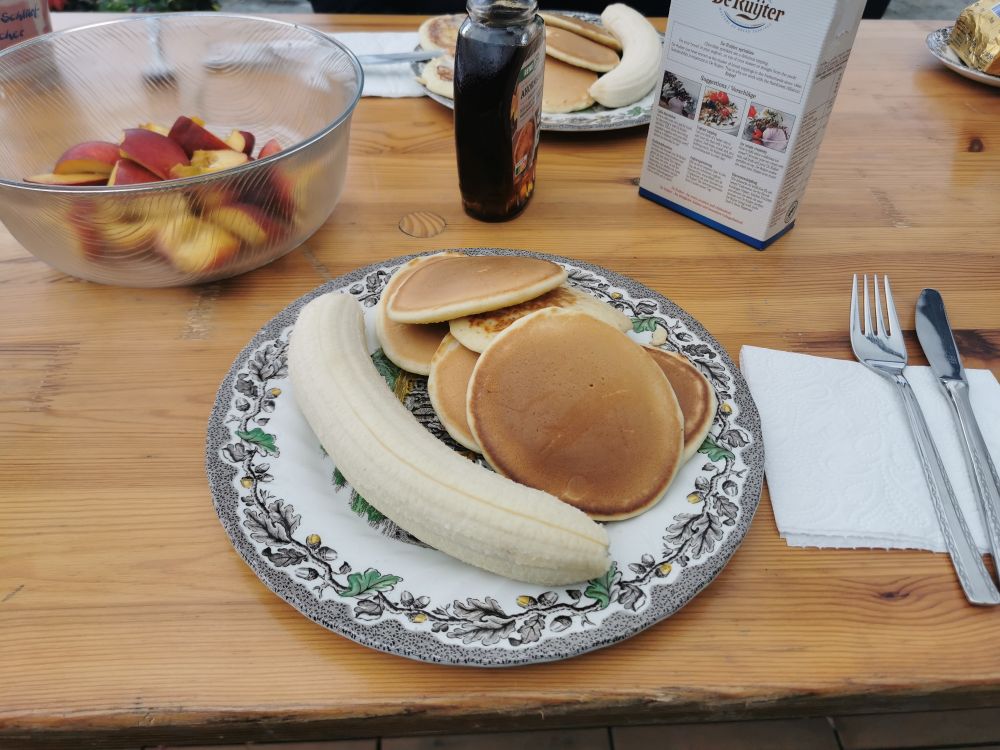 Ein Frühstückstisch mit Pancakes und Obst
