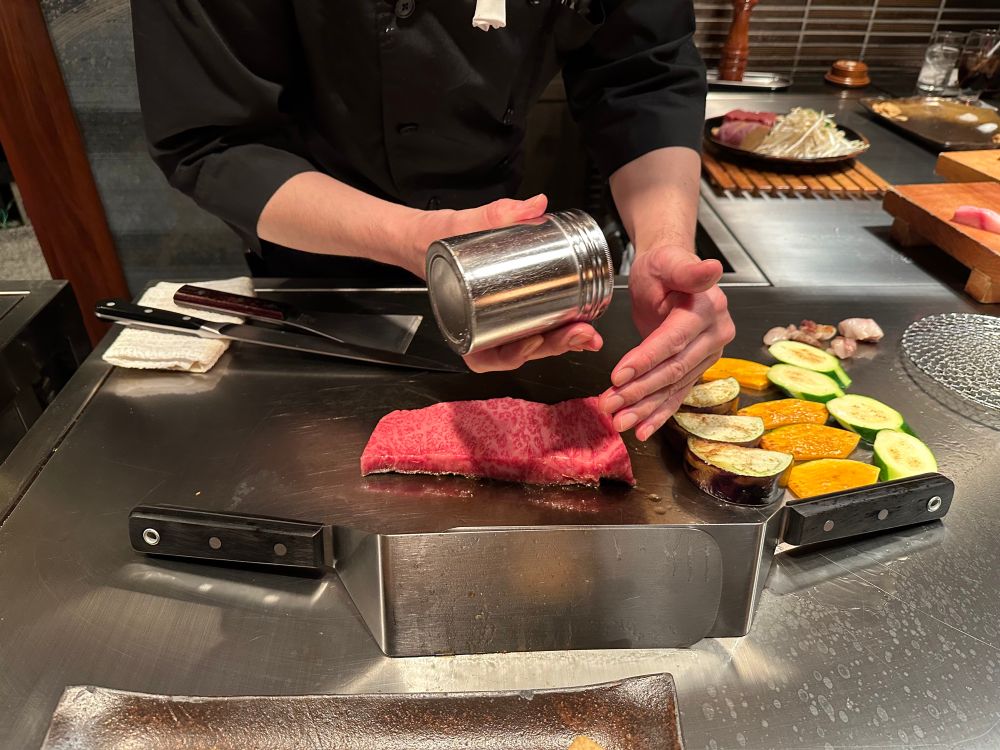 Chef at a teppanyaki restaurant preparing Kobe beef. 