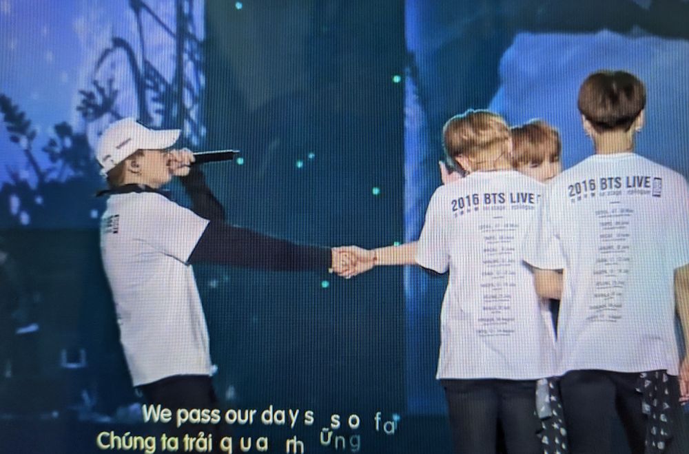 Arms outstretched, Yoongi clutches Namjoon's hand onstage during HYYH choreography.