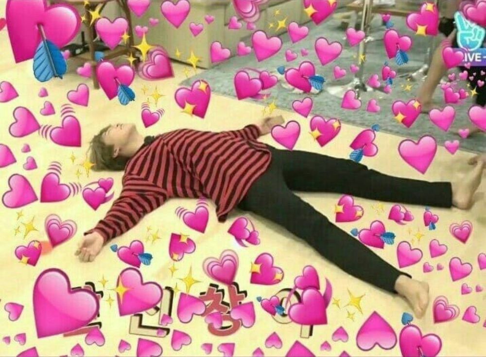 A young person lies on the floor, arms outspread, surrounded by heart emojis.