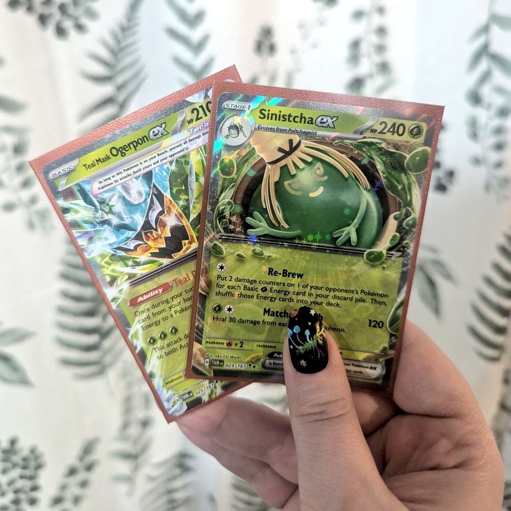 Holding up Teal Mask Ogerpon ex and Sinistcha ex