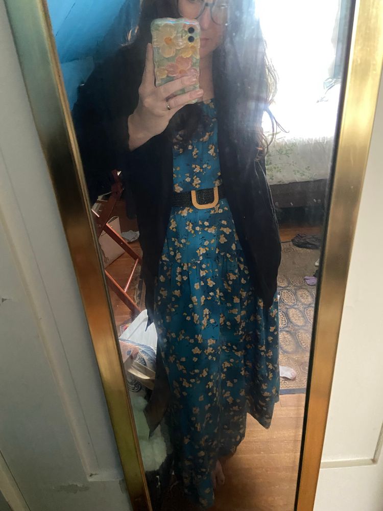 Old lady, hair loose, messy room, long dress, belted, dark cardigan.