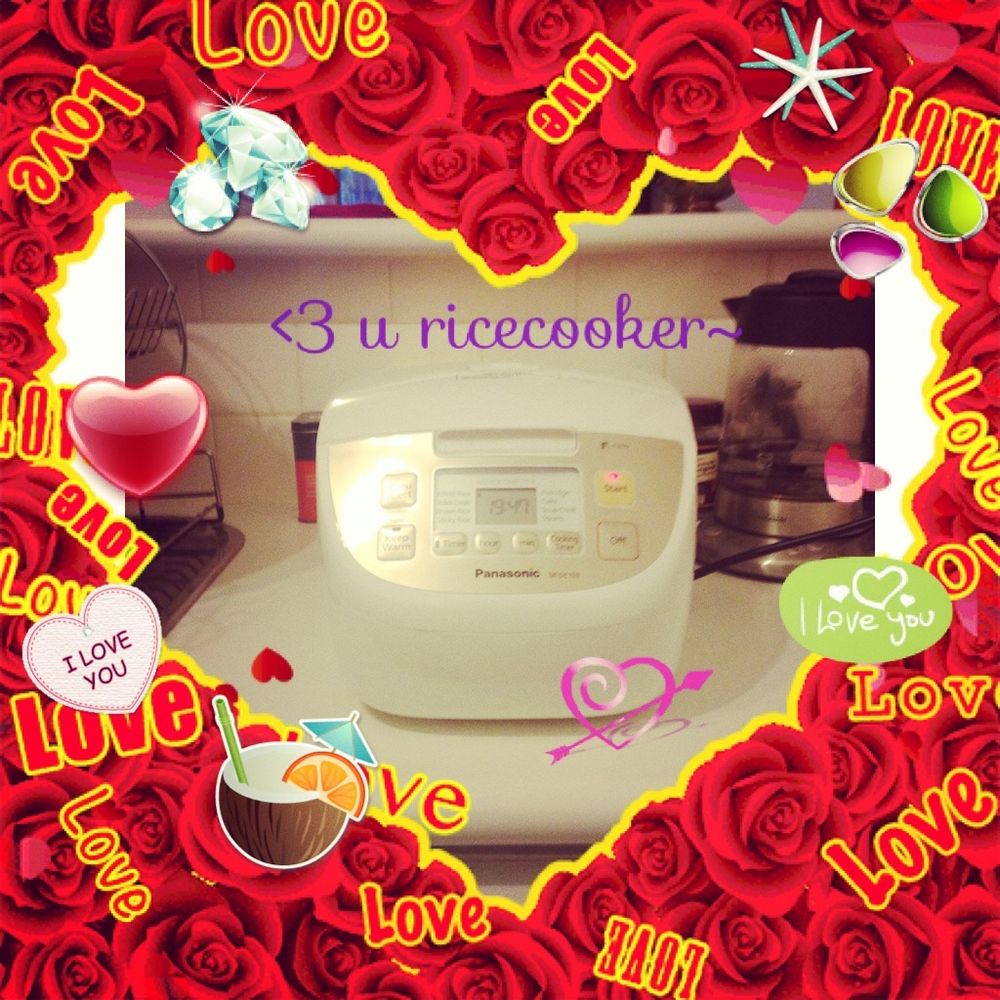 A white rice cooker on bench, surrounded by a heart shaped frame of roses and the word “love” in various fonts. 