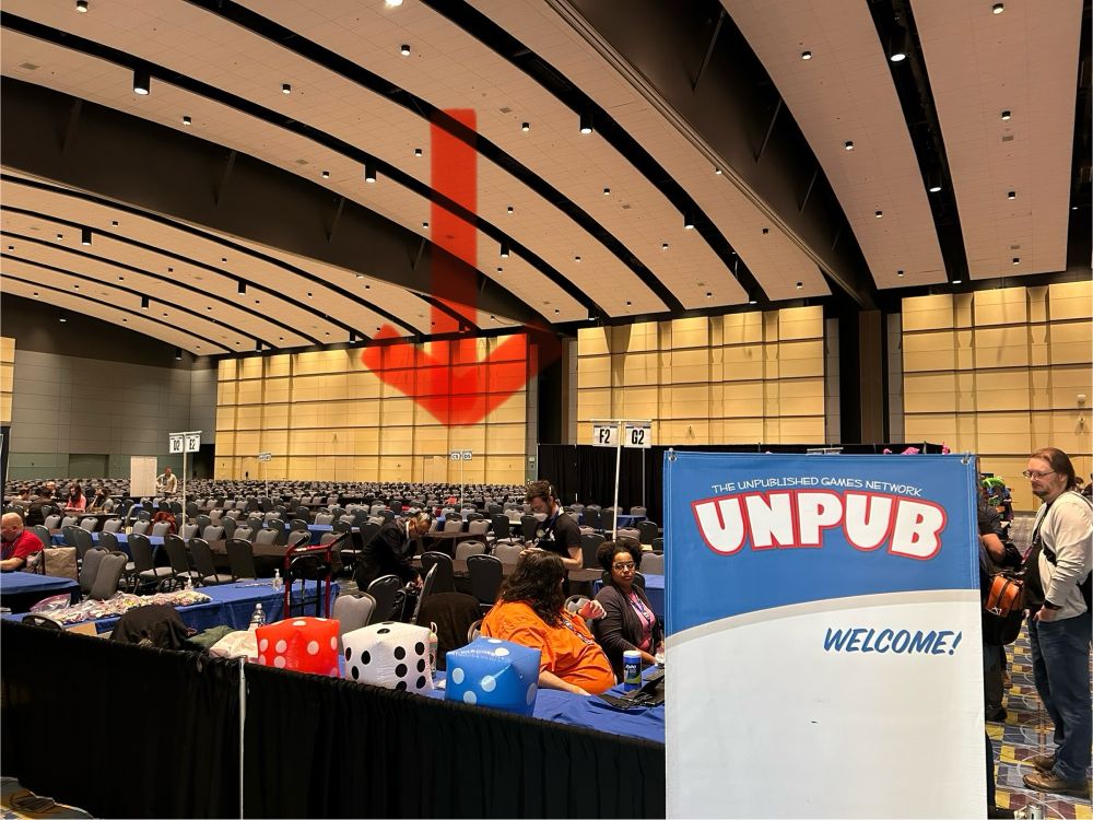 The Unpub room at PAX Unplugged, with a red arrow pointing out GMGP table C5