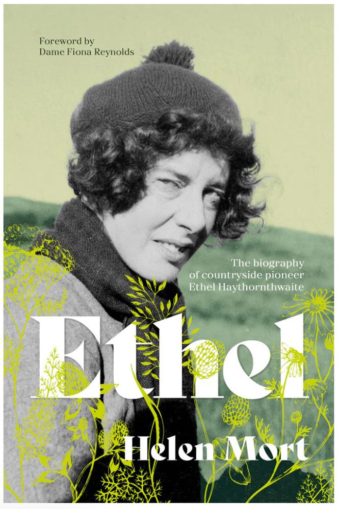 book cover of Ethel, with title and author in large solid white text and yellow drawings of plants woven through. Overlaid on a background of a photograph of a woman in black and white looking at the camera with short curly hair and a wooly hat. muted green background.