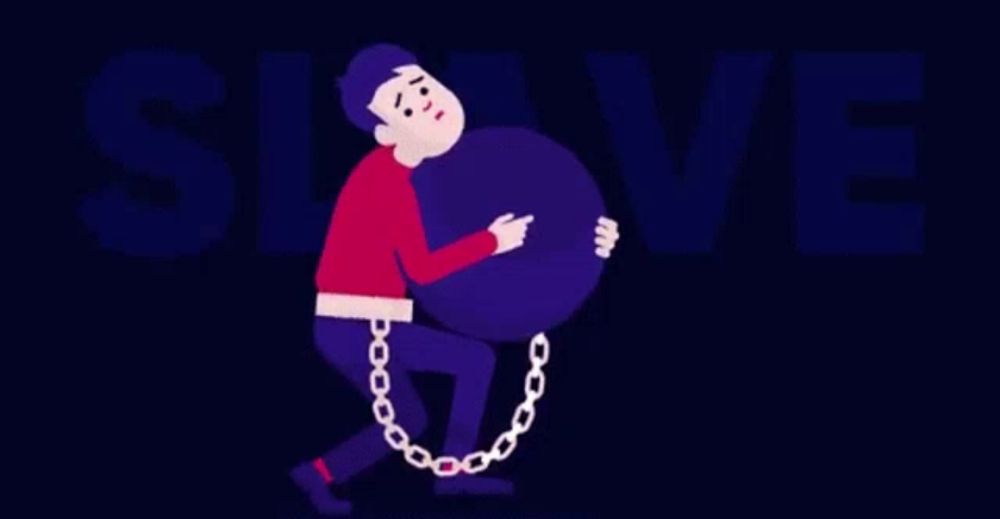 a man is chained to a large purple ball and is carrying it .