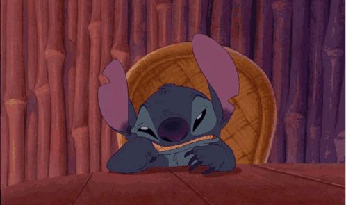 a cartoon of stitch sitting in a chair with a purple background