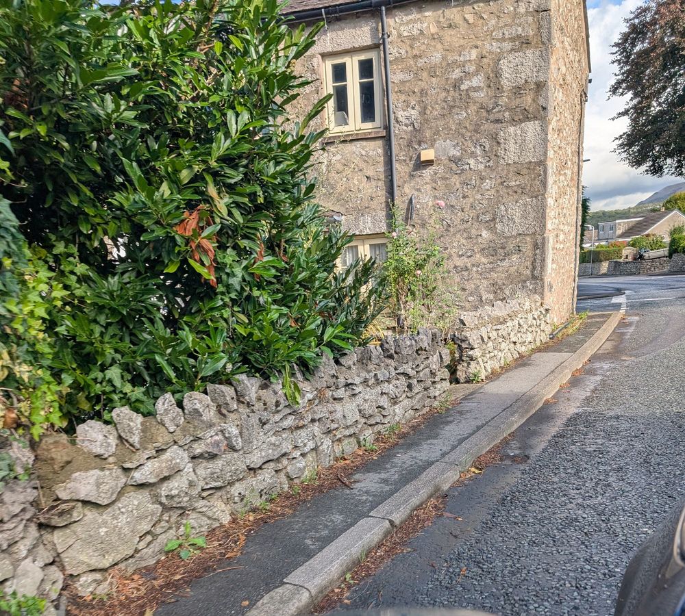 Pretty village view along a road. The pavement is about a foot wide. 