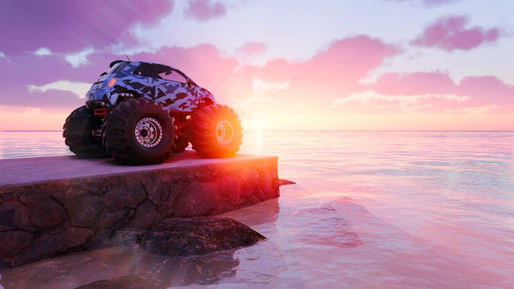 Sunset behind a monster truck that’s parked on a dock
