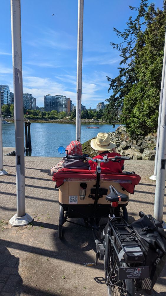 Passenger trike with two people in the front, looking out over water