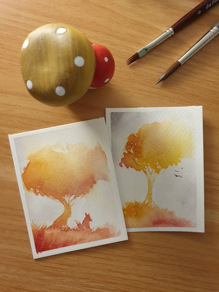 Zwei kleine Aqaurellbilder in den gleichen Farben gemalt zeigen einen Baum in Herbstfarben.