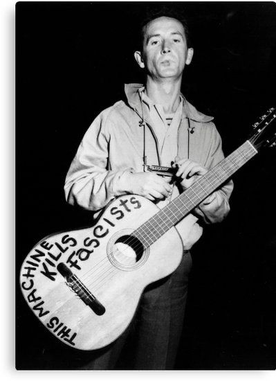 Woody Guthrie with his “this machine kills fascists” guitar. Taken during WW II