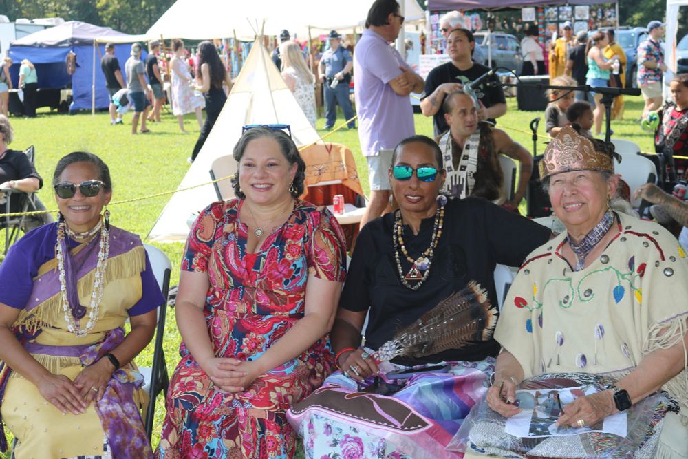 Photo of Rep. McClellan sitting and smiling with the Tribal Council President, Chief Lynette Allston and attendees at the Nottoway Indian Tribe Powwow.
