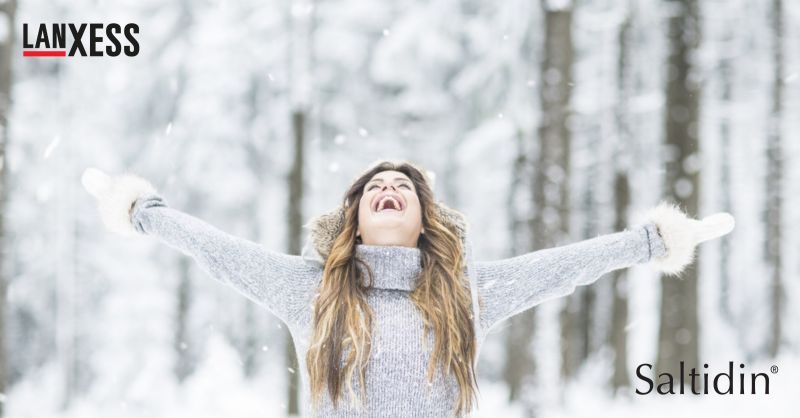Eine Frau läuft durch einen verschneiten Wald.