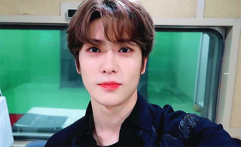 Jaehyun smiling with a little giggle.