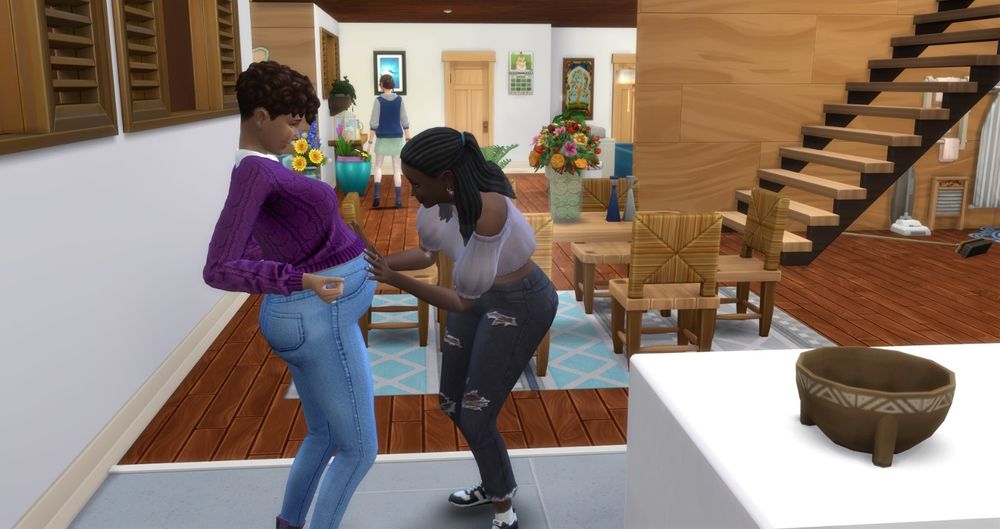 My pregnant teen Sim Athena on the left. On the right is her Aunt Mae who is bending down and feeling the bump 