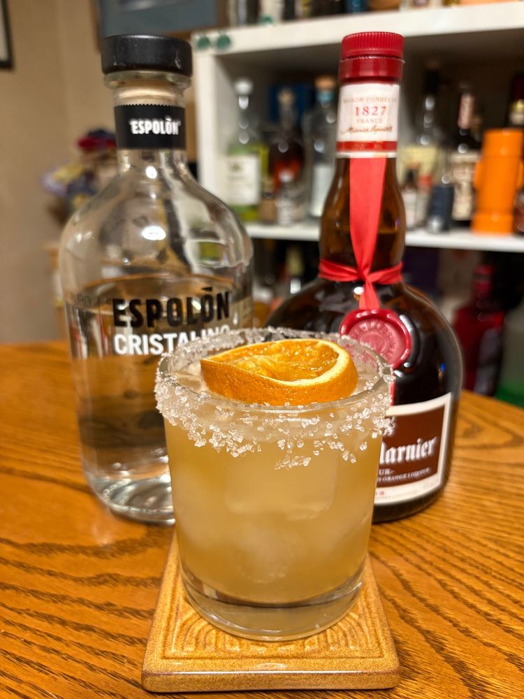 Margarita with a salted rim and an orange slice floating on top.