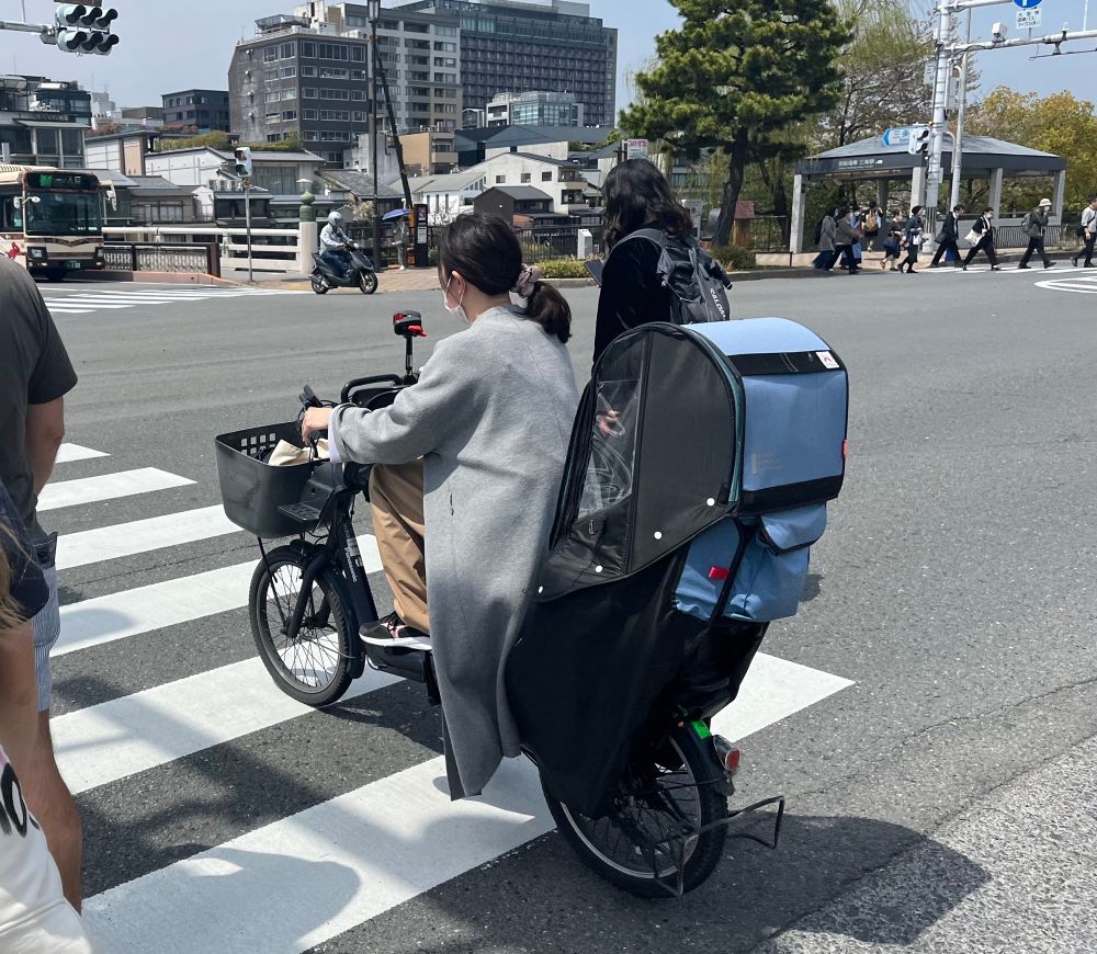 Younger woman on a bike with a kid seat