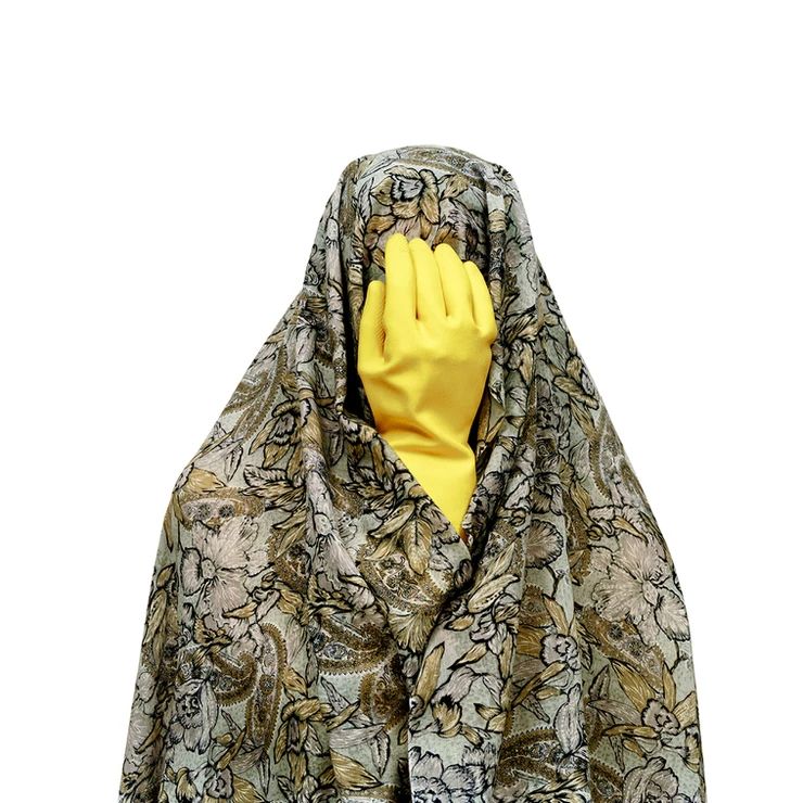 Photographie en couleur représentant une figure entièrement enveloppée dans un tissu floral beige et vert, rappelant un voile traditionnel. À la place du visage, une main gantée de jaune vif, typique des gants de ménage, vient masquer les traits, créant une image à la fois absurde et critique. Cette juxtaposition entre le tissu traditionnel et l’outil domestique symbolise les attentes culturelles imposées aux femmes, notamment la répétition des tâches ménagères. Issue de la série “Like Every Day” de la photographe iranienne Shadi Ghadirian, l’œuvre utilise l’humour visuel pour dénoncer les rôles stéréotypés et les pressions de la société patriarcale.