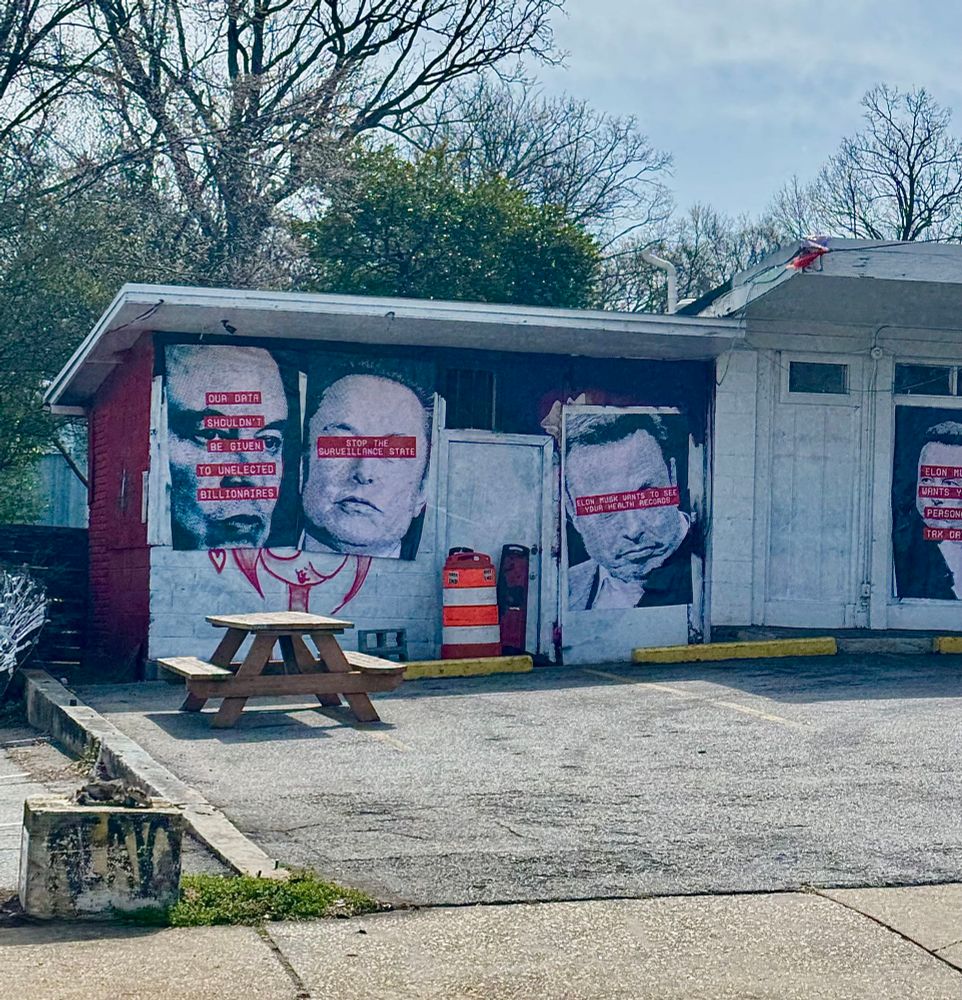 Photo of Anti Musk political street posters on a vacant building 