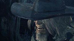 An old hunter that wears a black hat, has grey hair and beard. He has bandages over his eyes and has a crazed expression on his face showing his fangs.  