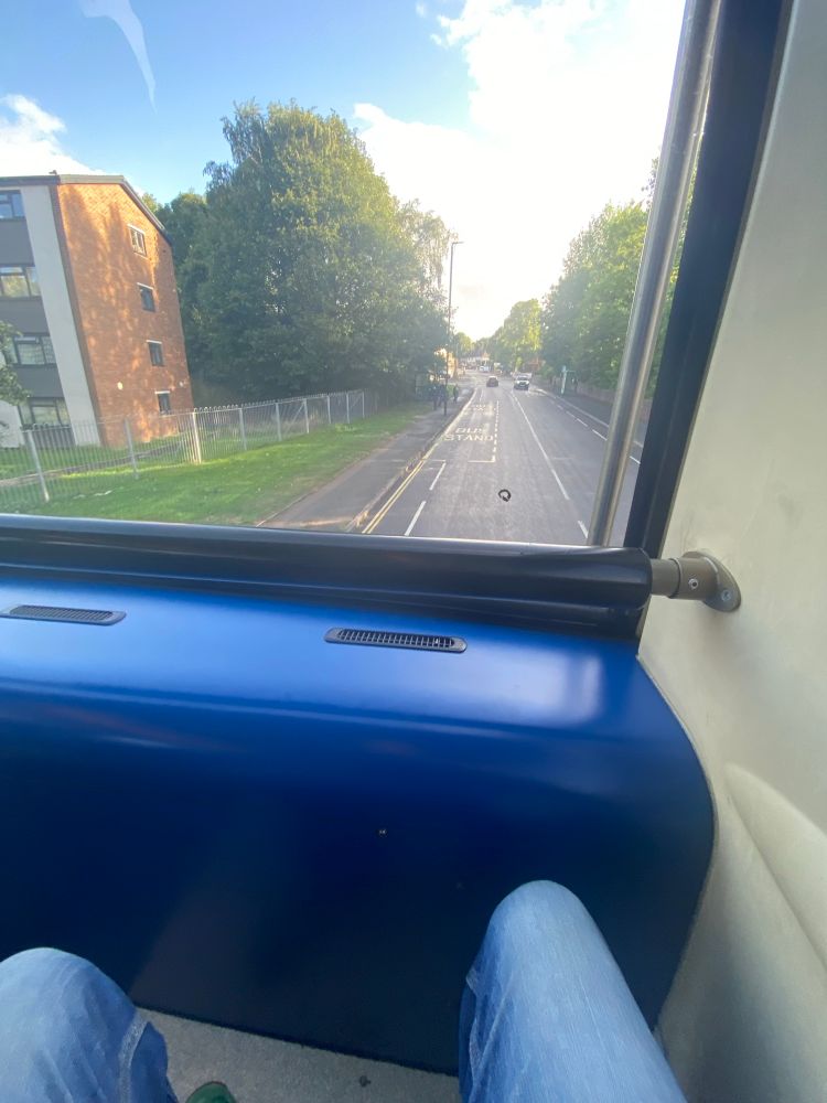 View from top deck, front seat of a double decker bus looking out onto the road