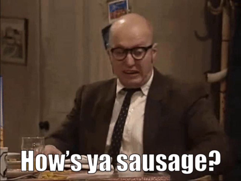 a bald man in a suit and tie is asking how 's ya sausage ?