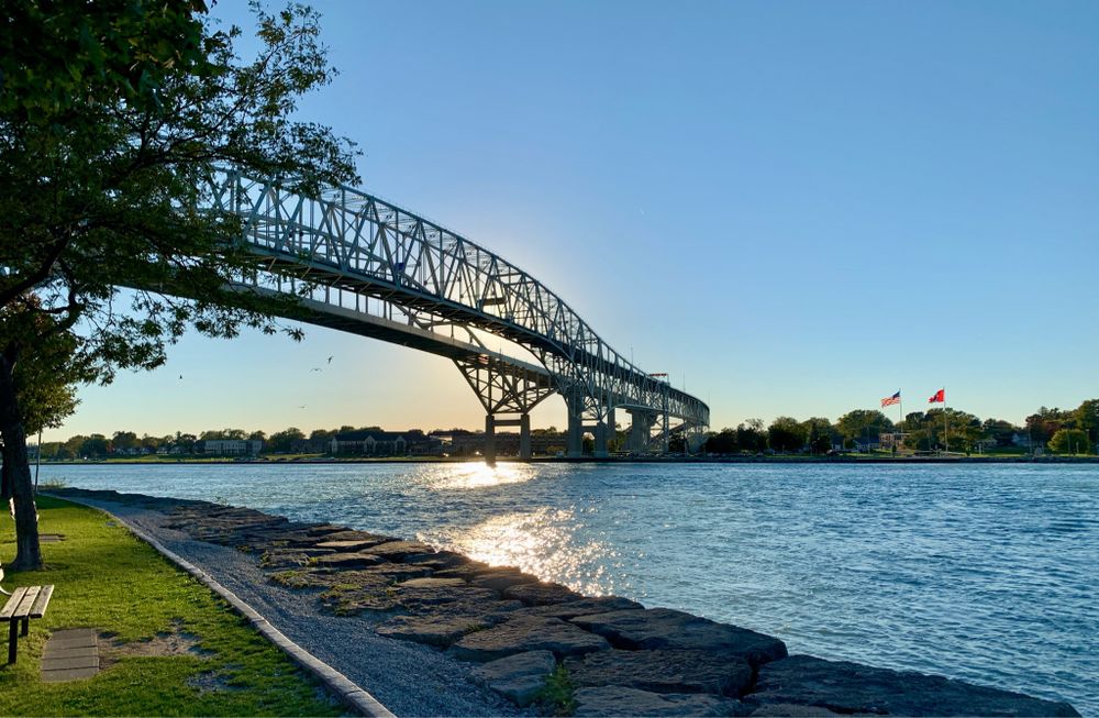 A bridge spanning the St. Clair River, backlit with the setting sun.