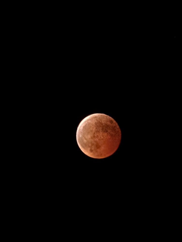 Reddish brown full moon image taken during lunar eclipse