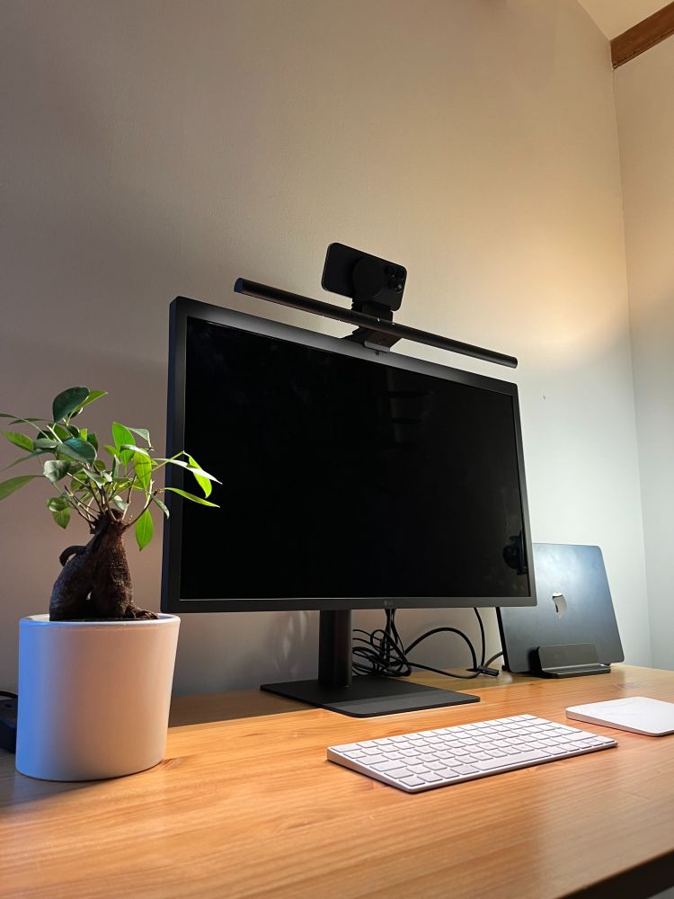 Picture of a monitor with the BenQ ScreenBar Pro on top and an iPhone as a webcam