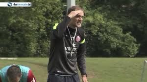 Thomas Tuchel im Mainz Trainingsanzug wie er etwas zu Shawn Parker sagt.