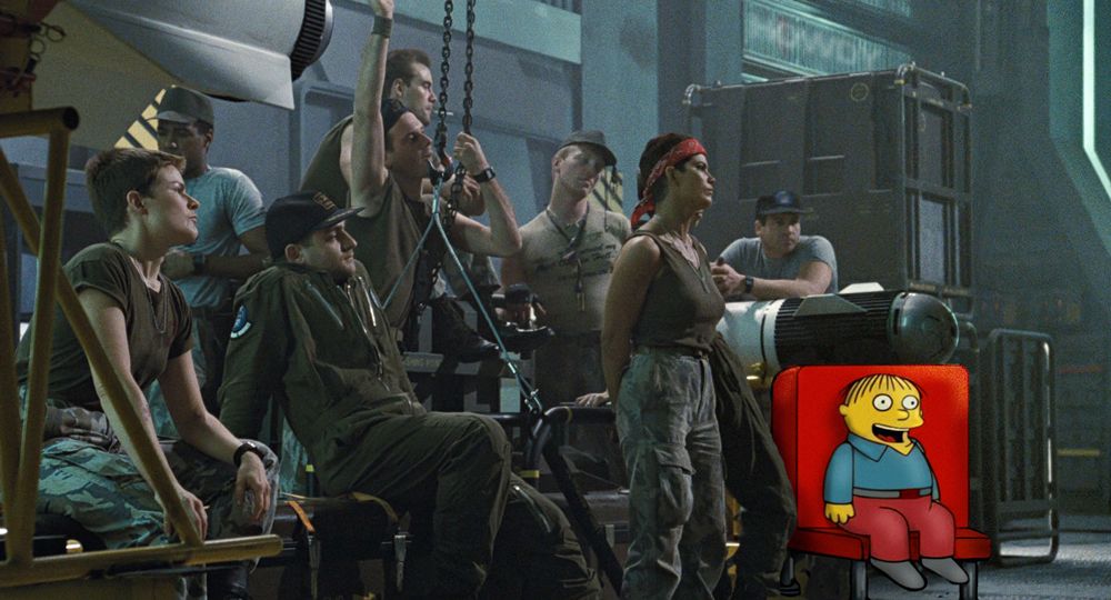 A scene from "Aliens" (1986) showing the assembled Marines awaiting their orders. Ralph Wiggum, from the "I'm in danger" meme, is sitting in a red chair among the marines with a big smile on his face.