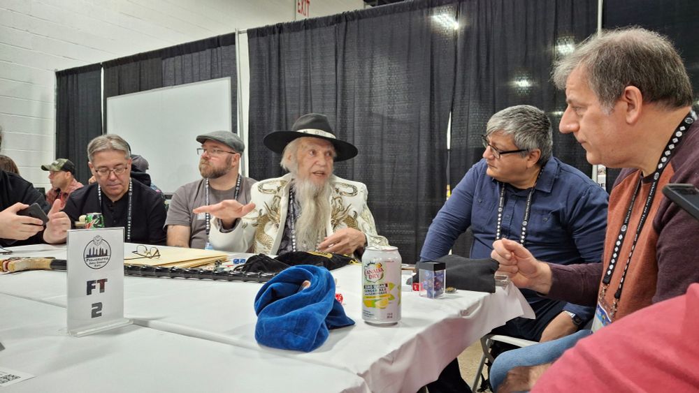 Frank Mentzer wearing a white dragon blazer, black TSR hat, with dragon-head cane, running D&D
