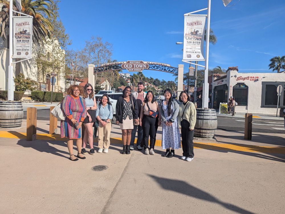Cell Biology Dros25 dine around participants cheerfully posing in front of a sign stating, "Historic Old Town San Diego".